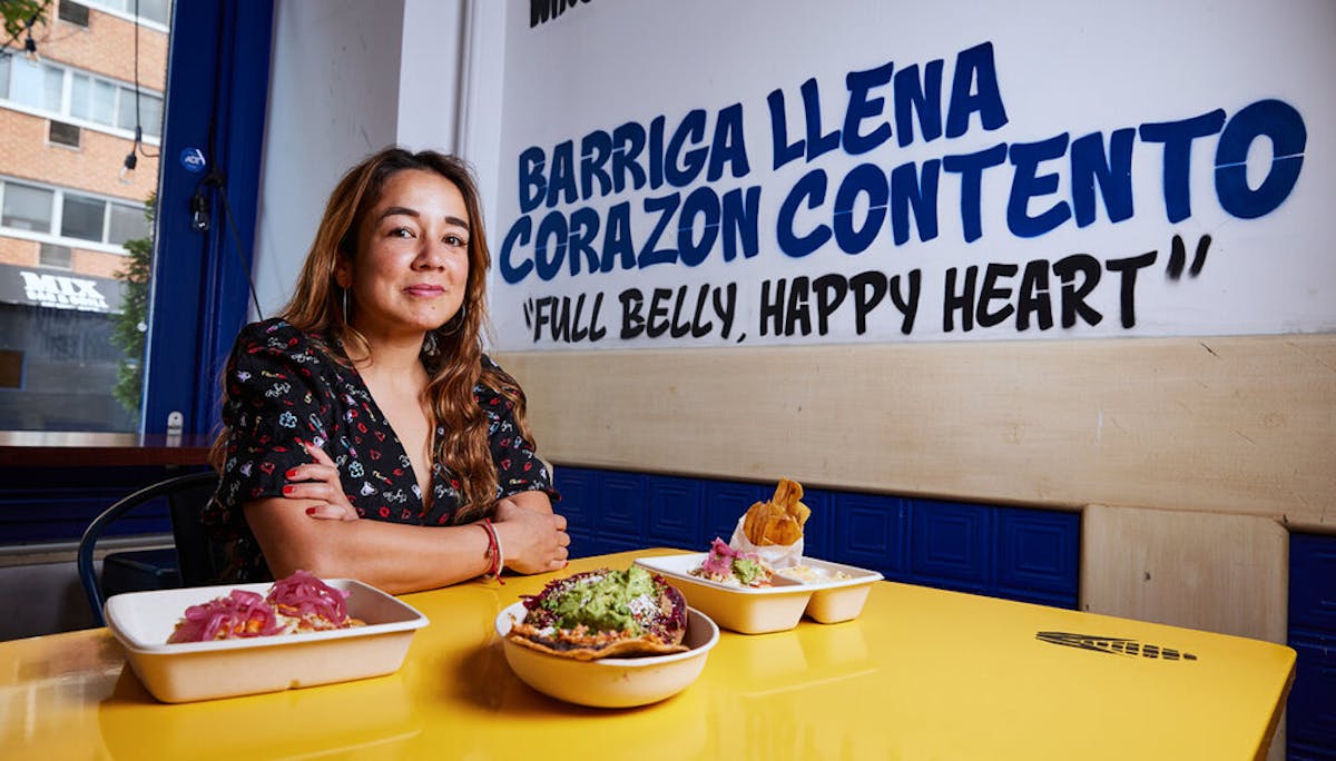 a woman sitting at a table in front of a building